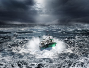 Fishing boat in a storm in the dark, frothy ocean