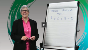 Sue smiling next to a whiteboard with change success formula
