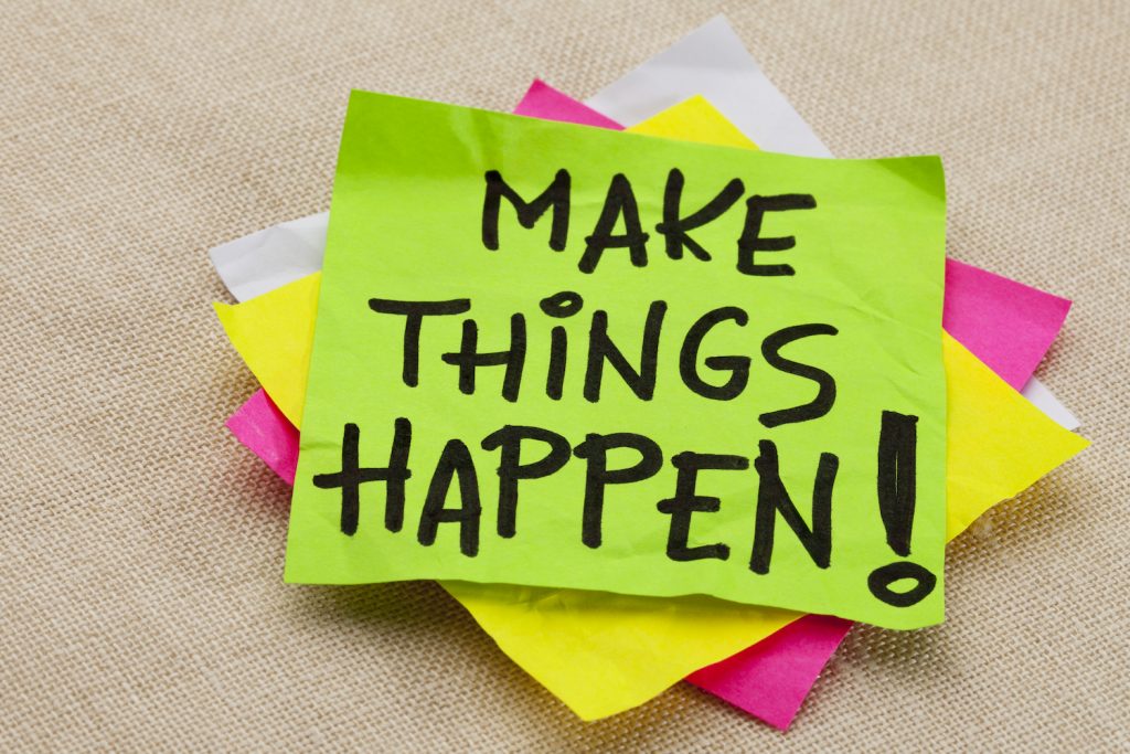 Make things happen motivational reminder - handwriting on a green sticky note