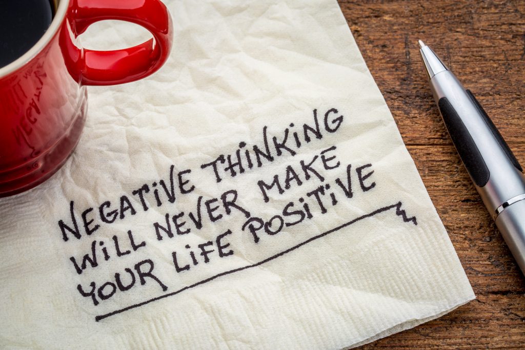 negative thinking will never make your life positive - inspirational handwriting on a napkin with a cup of coffee