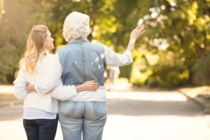 Always hug your parents. Inspiring greyish aging woman enjoying the sunny weather outdoors while expressing joy and hugging mature daughter